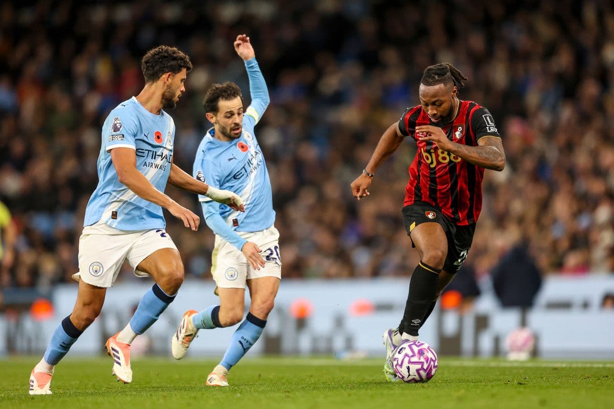 Bournemouth player dribbling past Manchester City defenders