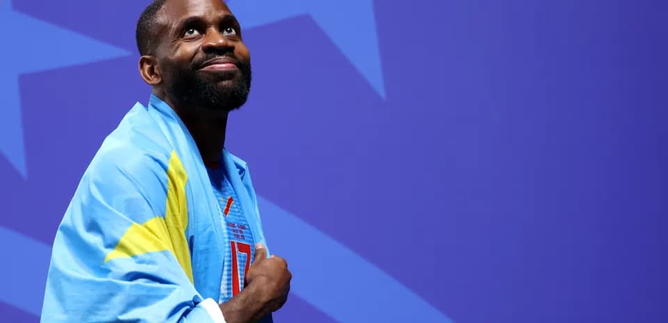 Athlete wearing flag, looking upward at event