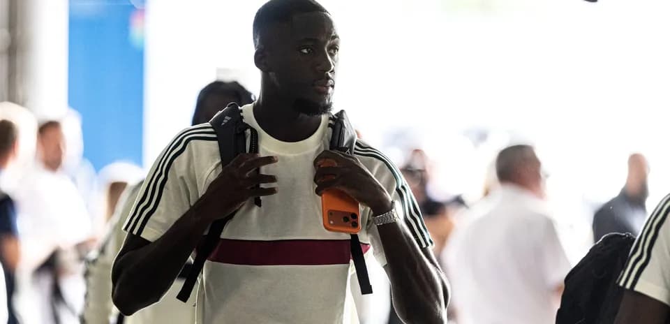 Player entering venue with backpack and phone