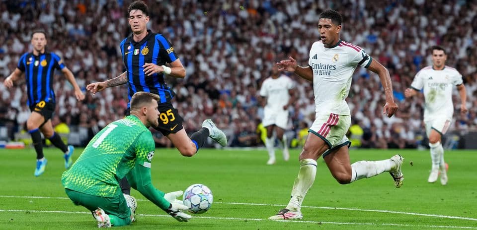 Player running past goalkeeper during UEFA Champions League match