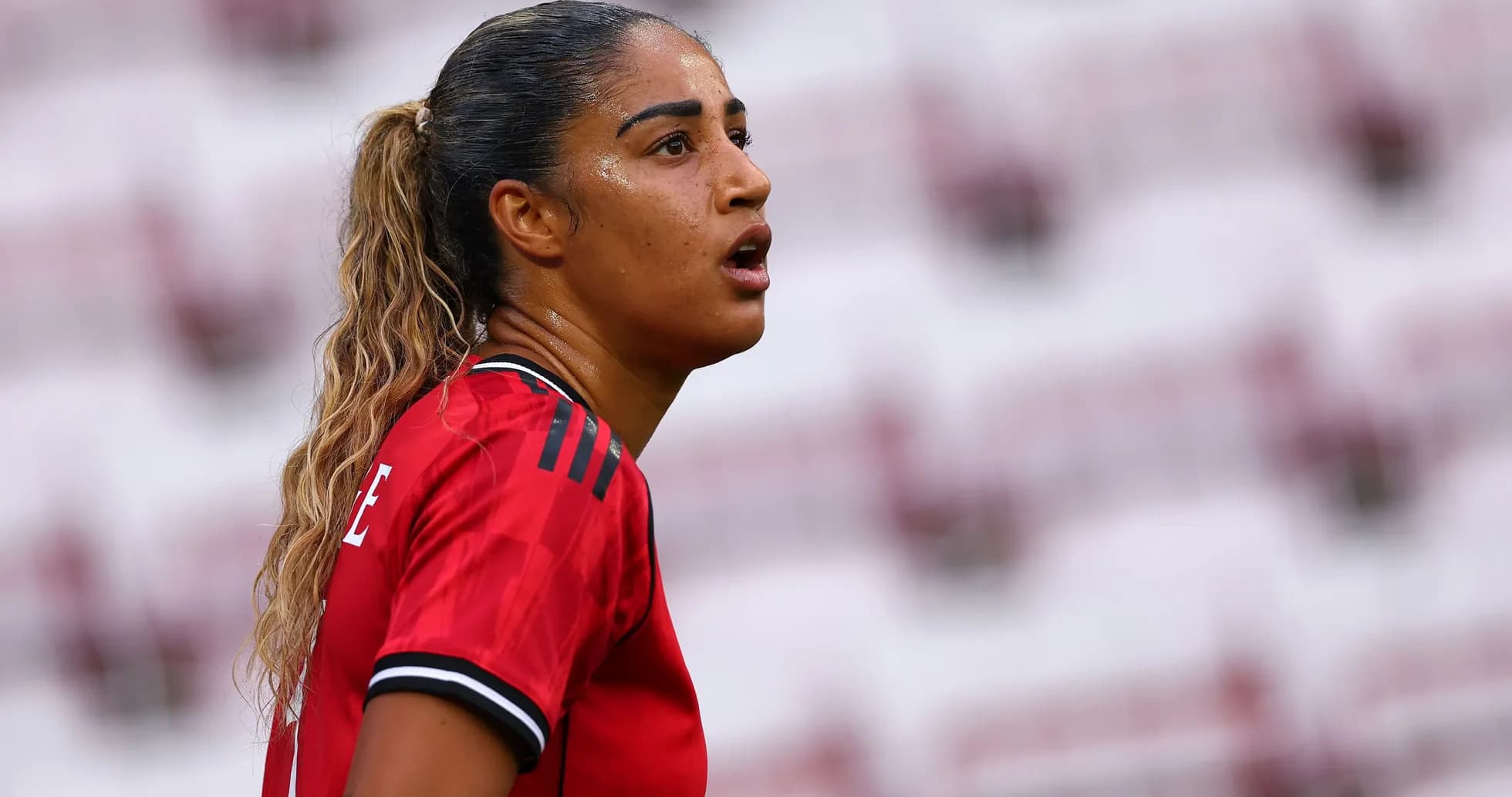 Player in red jersey looking during match