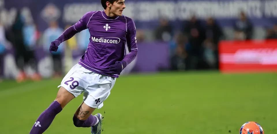 Player in purple kit sprinting for the ball
