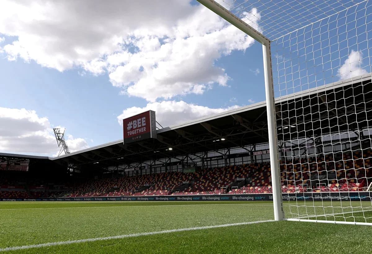 Goalpost with stadium and clouds in background
