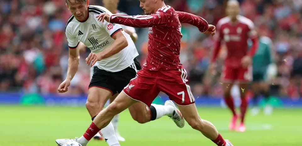 Liverpool player tackling Fulham opponent during match