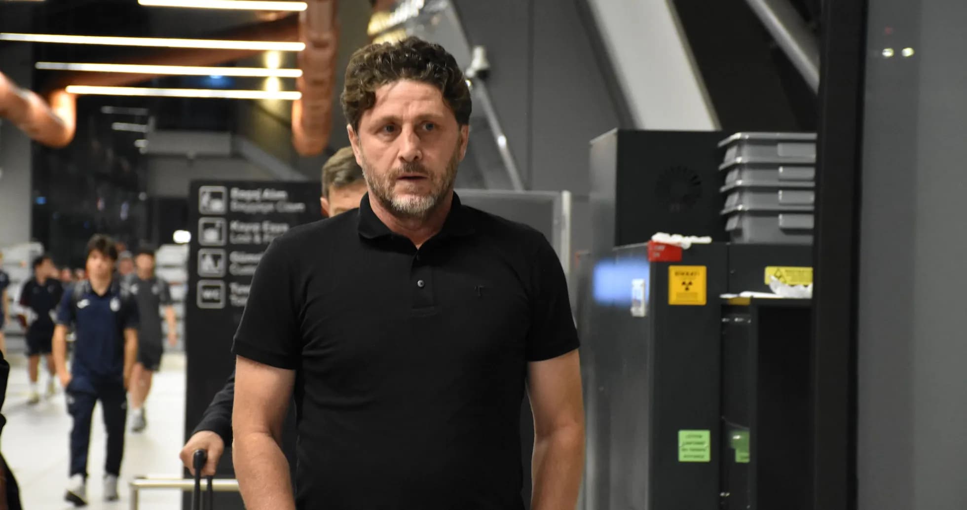 Man walking through airport terminal with luggage