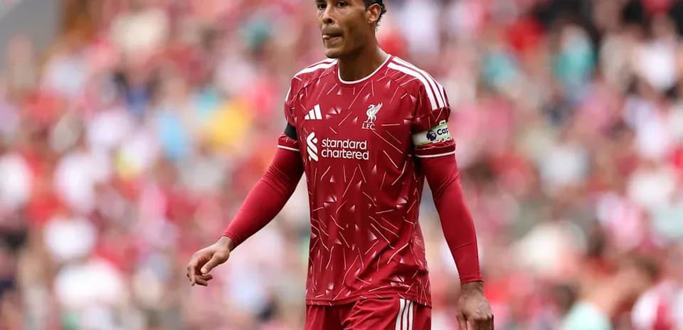 Player in red Liverpool kit walking on the pitch