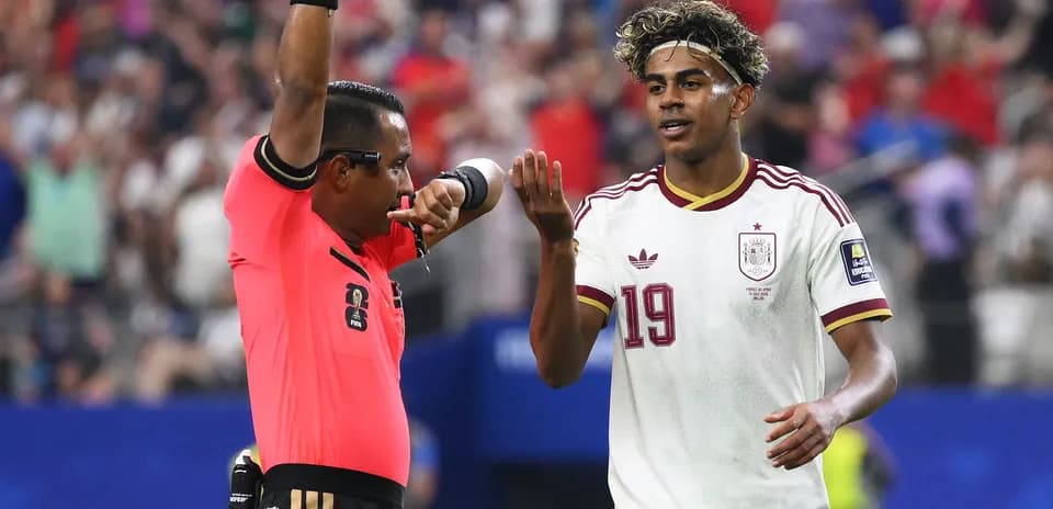 Referee showing a card to Spain player during match