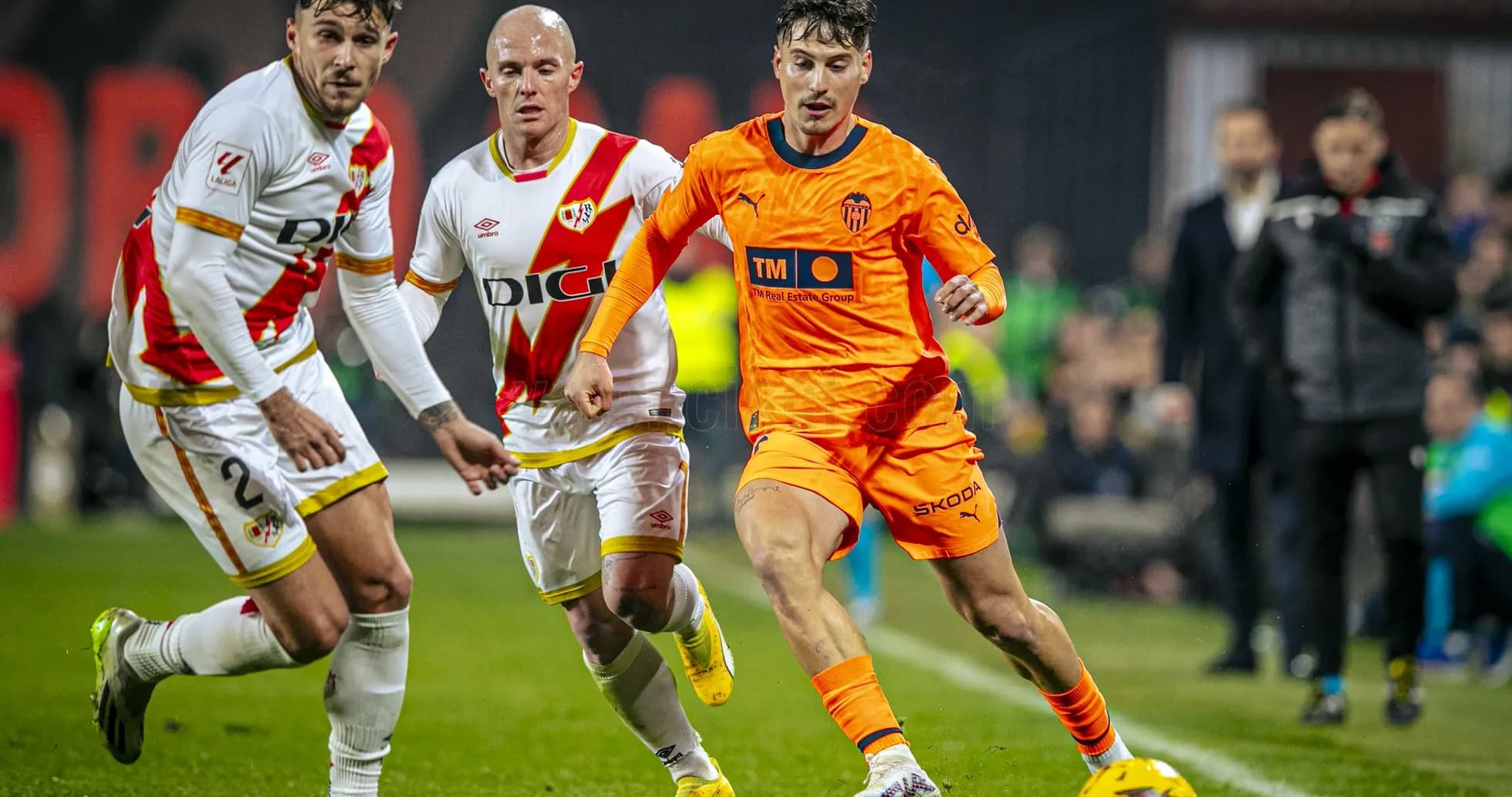 Valencia player dribbling past Rayo Vallecano defenders