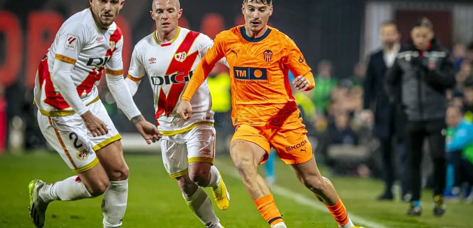 Valencia player dribbling past Rayo Vallecano defenders