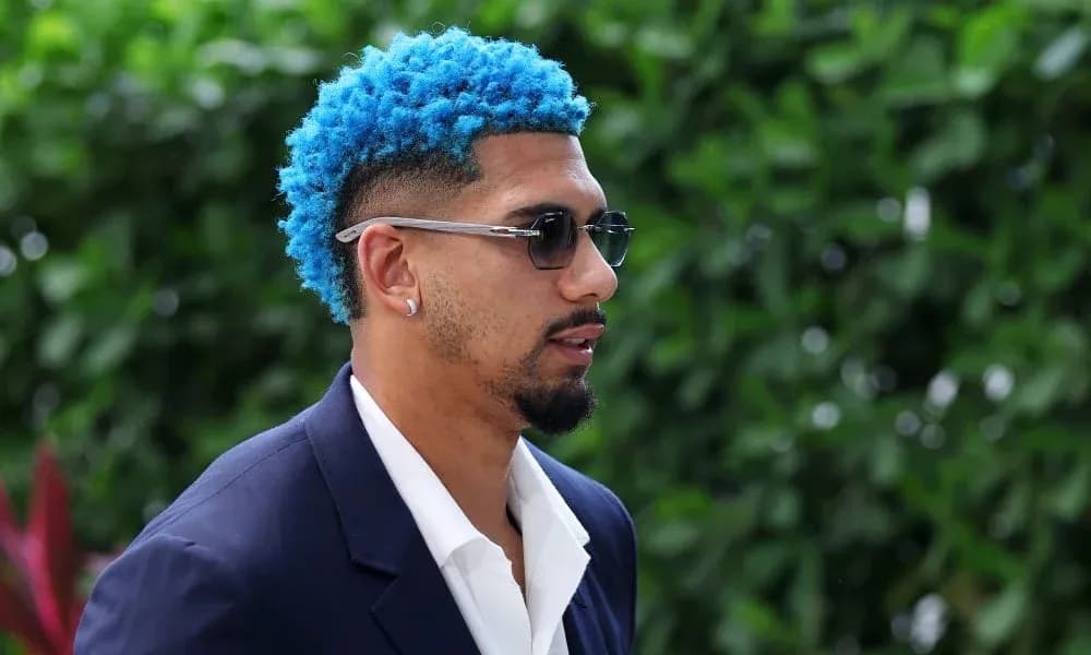 Person with blue hair and sunglasses outdoors