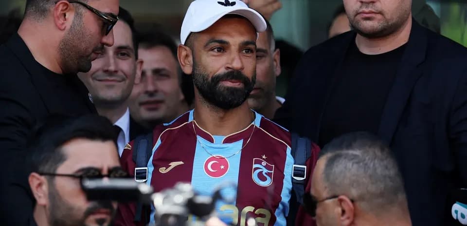 Player arriving surrounded by security personnel