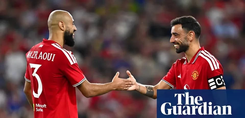 Two Manchester United players shaking hands on pitch