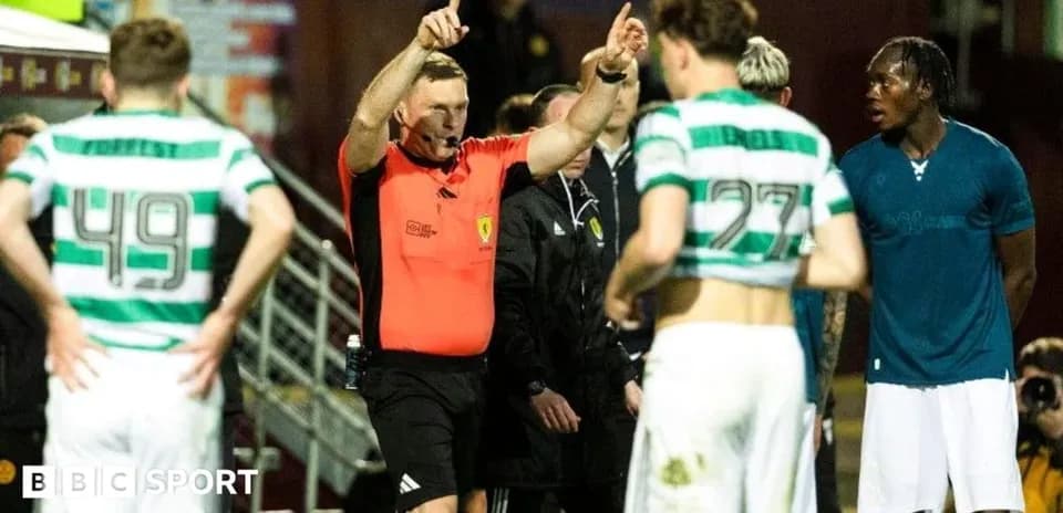 Referee gesturing during match with players nearby