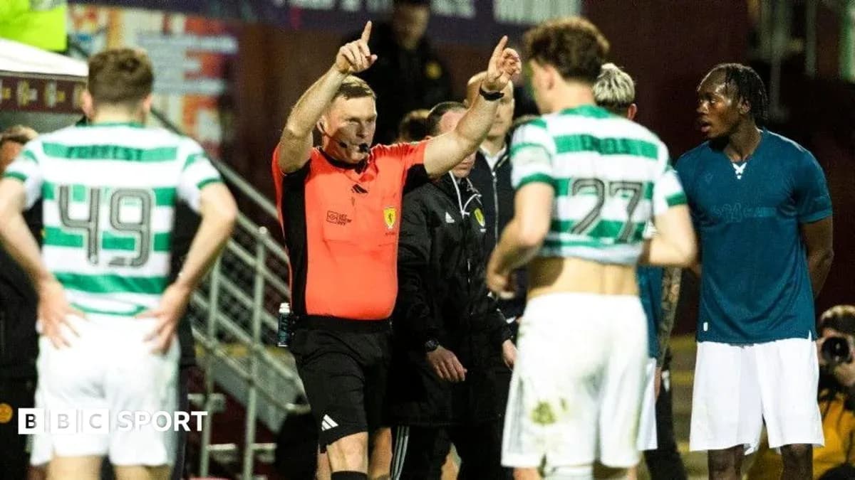 Referee gesturing during match with players nearby
