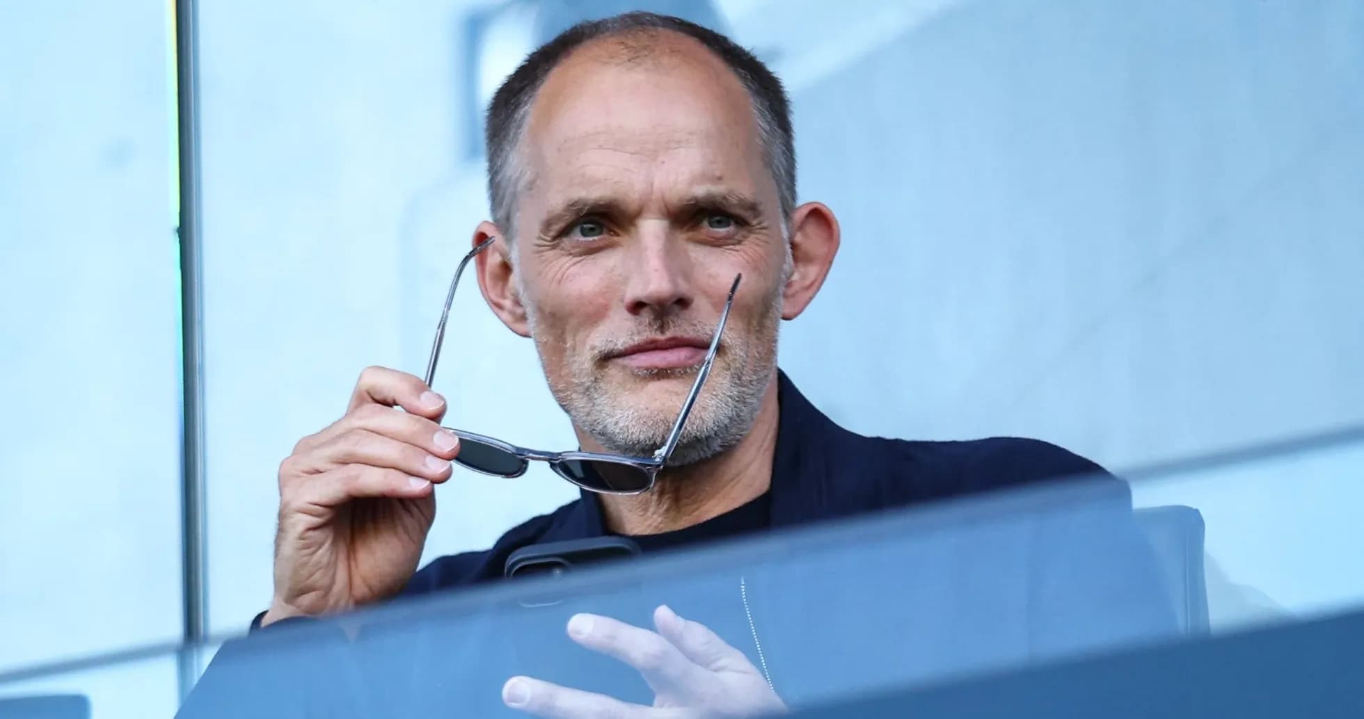 Man holding glasses while looking thoughtfully