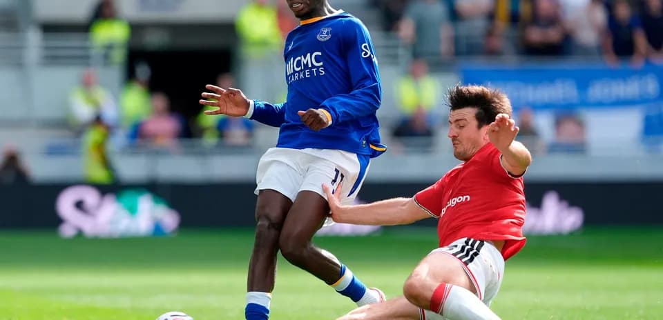 Everton player tackling Manchester United opponent