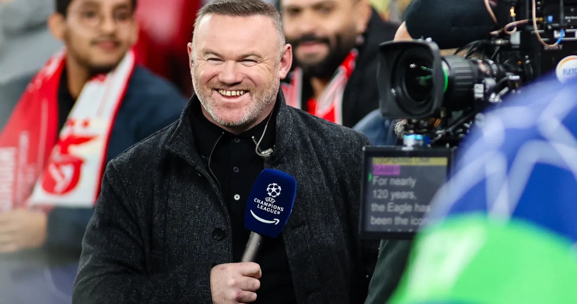 Presenter smiling with microphone at UEFA Champions League