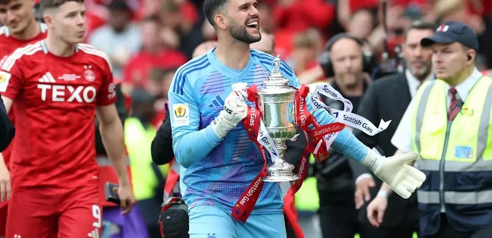 Goalkeeper celebrating with trophy after match