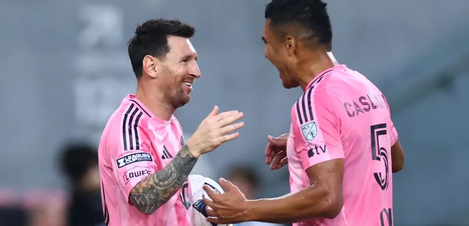 Players celebrating during a match in pink uniforms