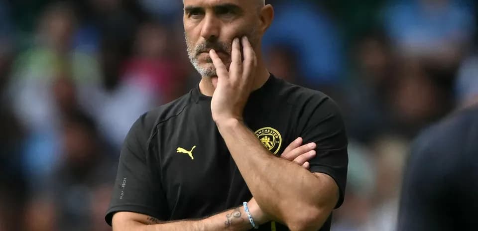 Manager observing the match with a thoughtful expression