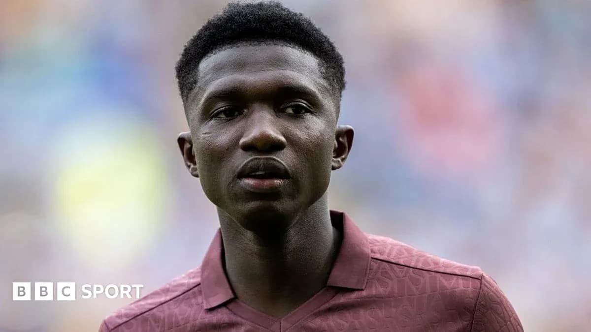 Player in maroon kit during match warm-up
