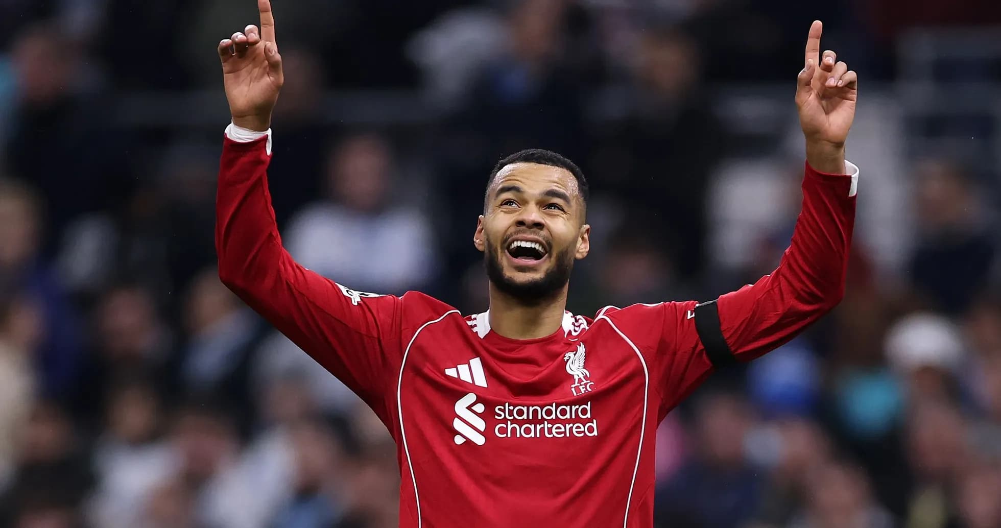 Player celebrating with arms raised in Liverpool jersey