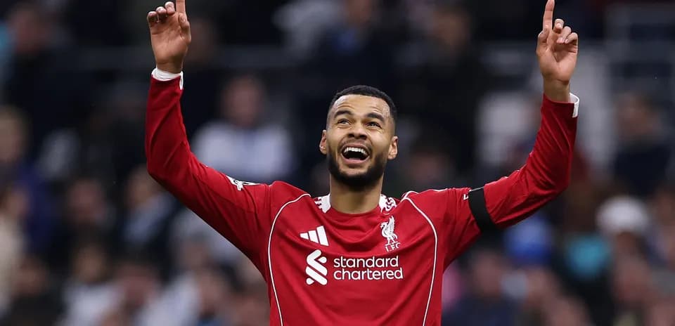 Player celebrating with arms raised in Liverpool jersey