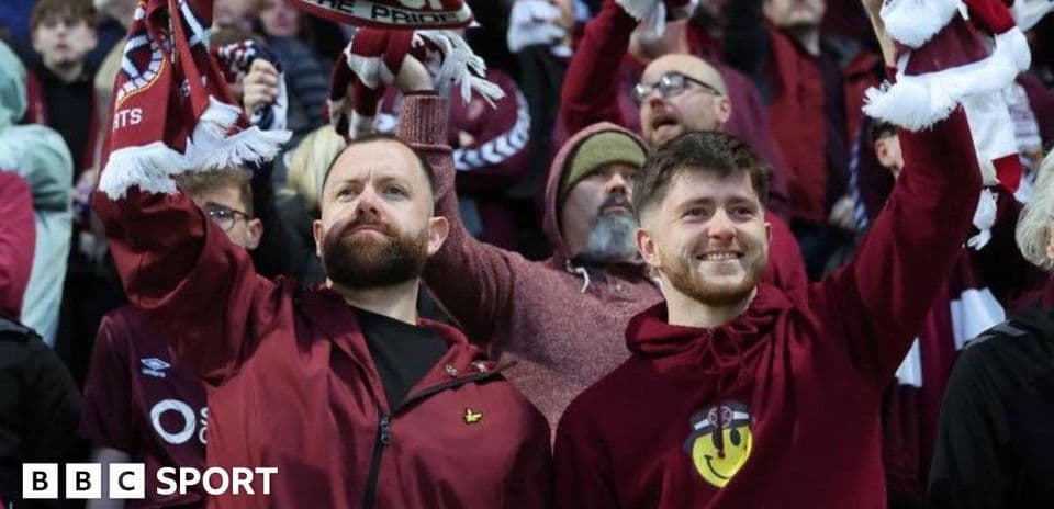 Fans cheering with scarves in stadium crowd