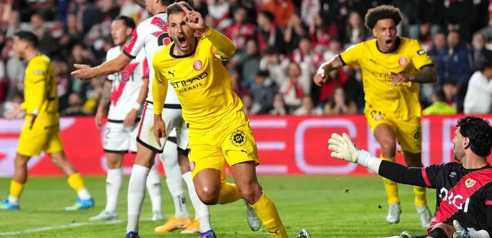 Player celebrating after scoring a goal against goalkeeper