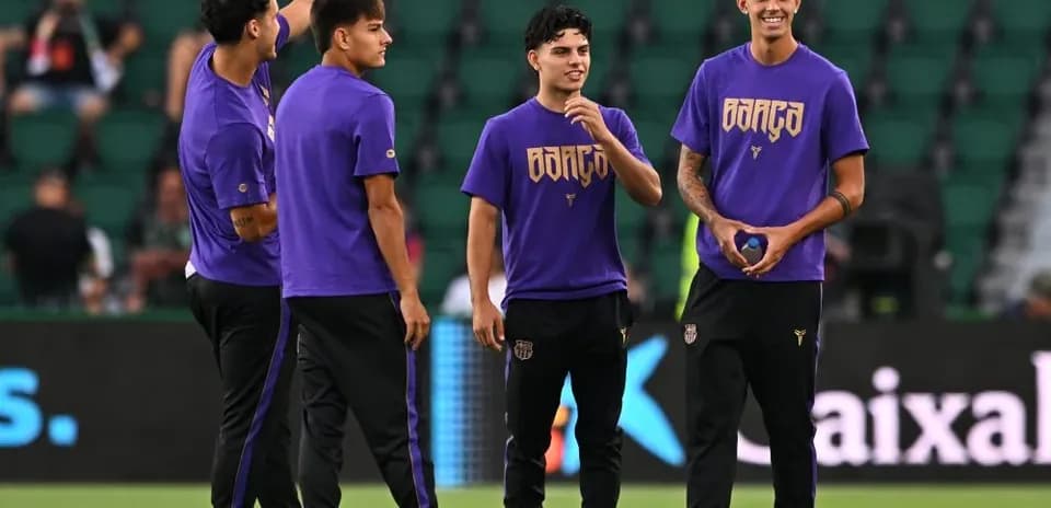 Four players in purple shirts warming up on field