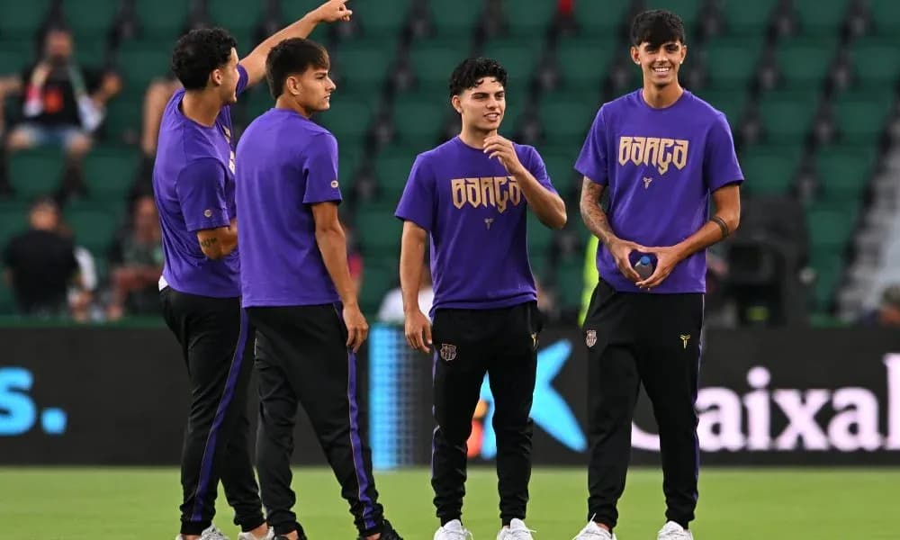 Four players in purple shirts warming up on field