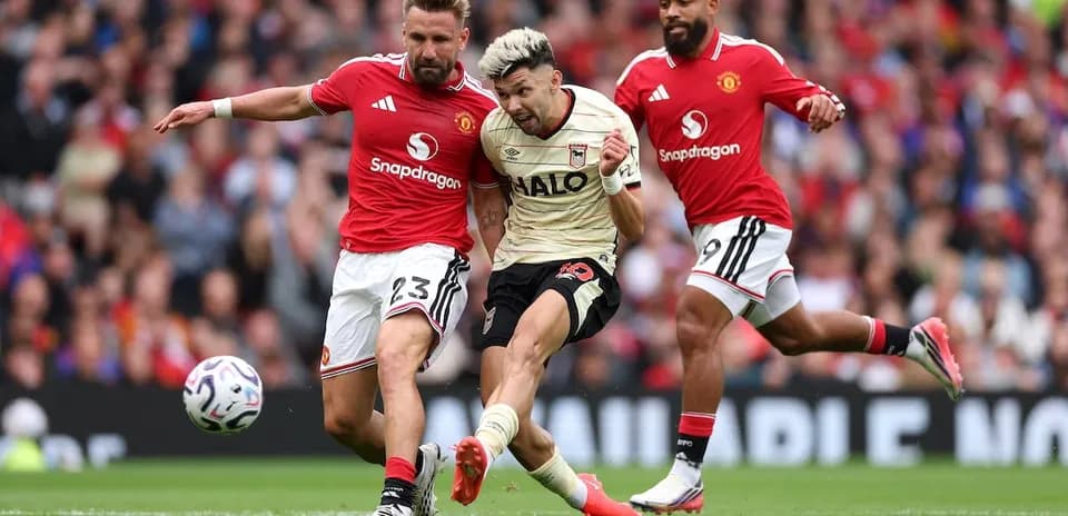 Manchester United players tackling Ipswich player