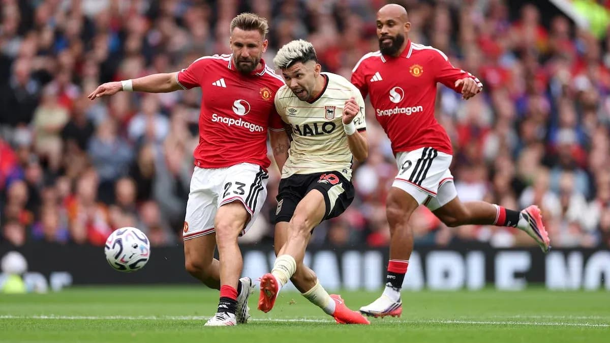 Manchester United players tackling Ipswich player