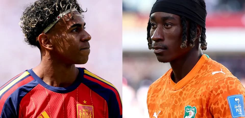 Two soccer players in team jerseys facing each other