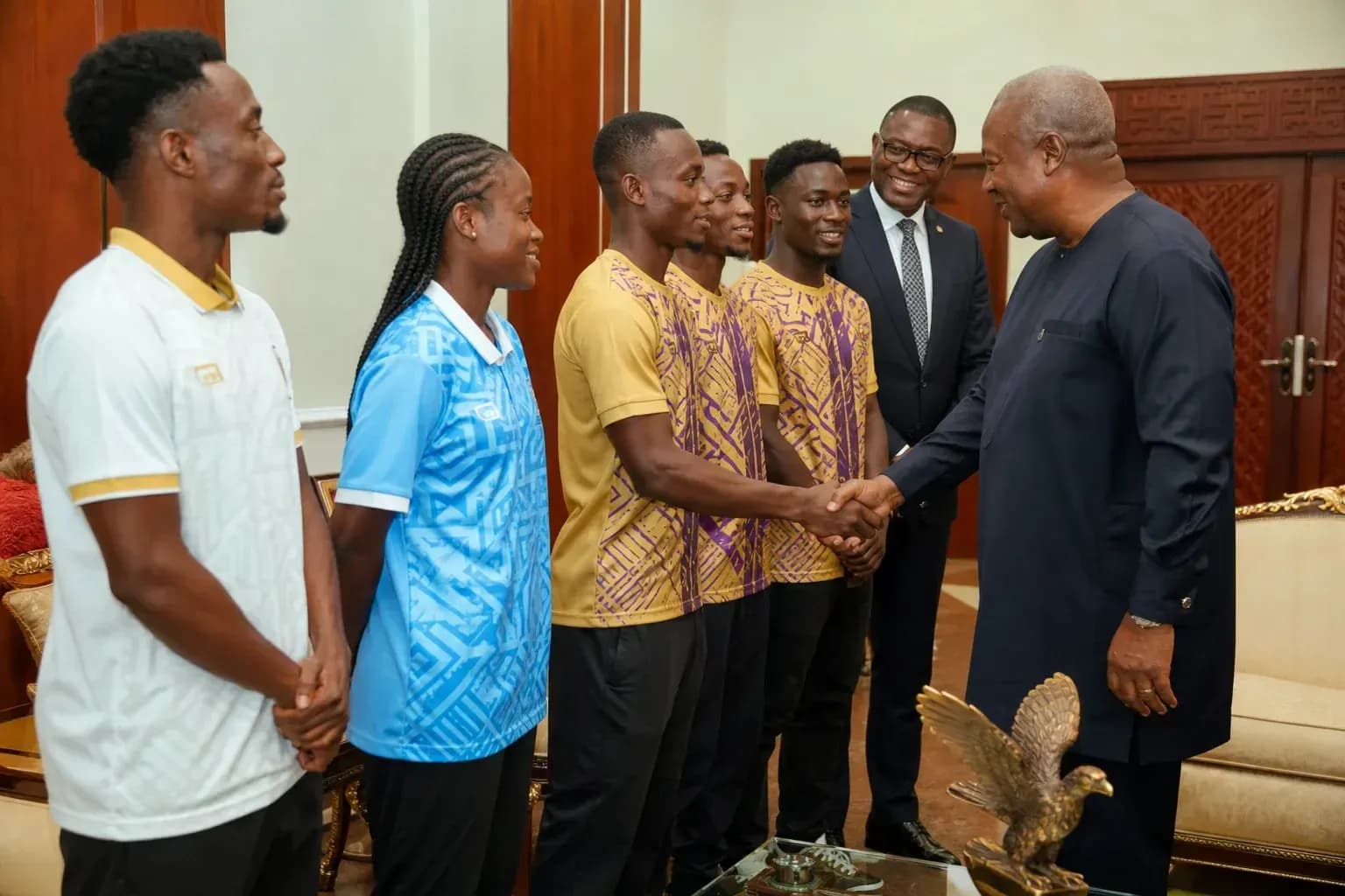 Athletes shaking hands with official in meeting