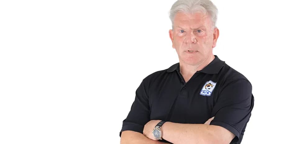 Man with arms crossed wearing a black polo shirt