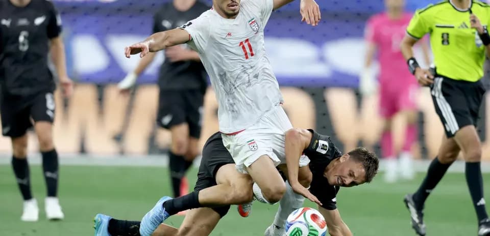 Iran player tackling New Zealand opponent during match