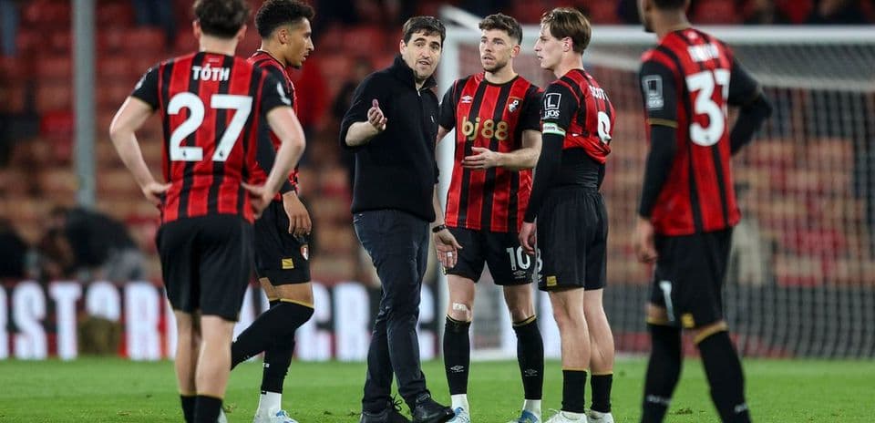 Coach discussing strategy with players on the field