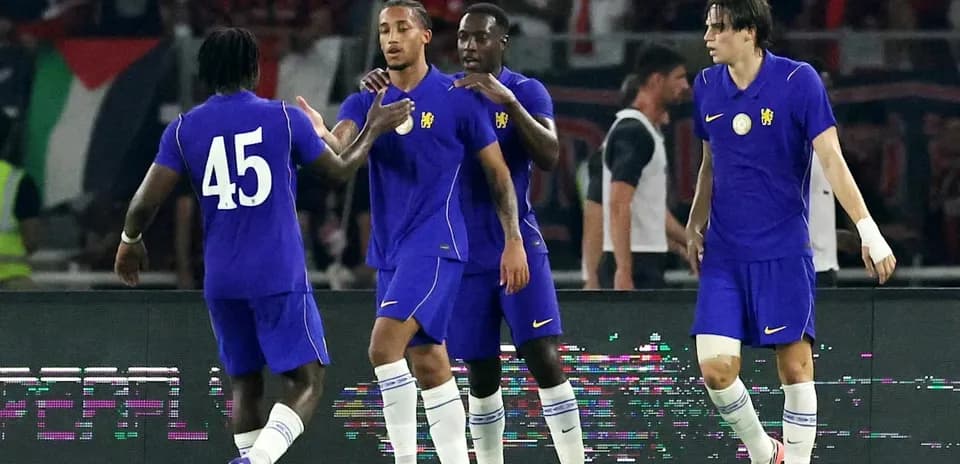 Four players celebrating a goal in purple jerseys