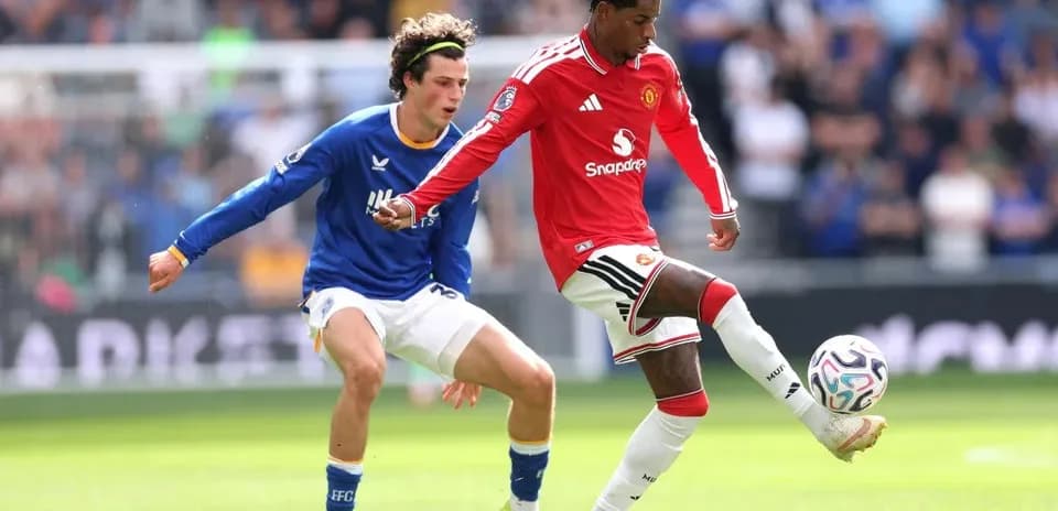 Manchester United player dribbling past Everton defender