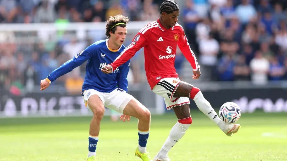Manchester United player dribbling past Everton defender