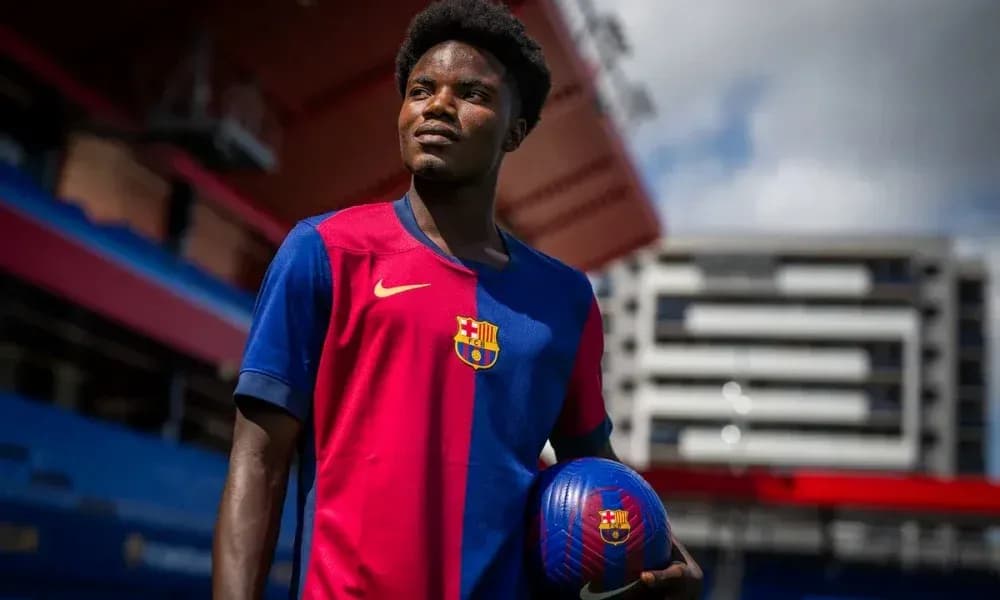 Player in Barcelona jersey holding a football