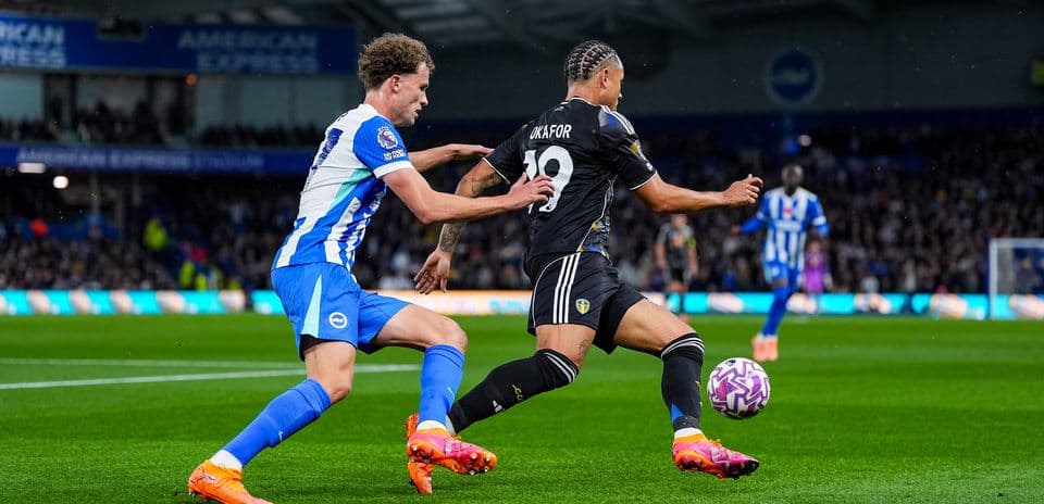 Leeds player attempting to evade Brighton tackle