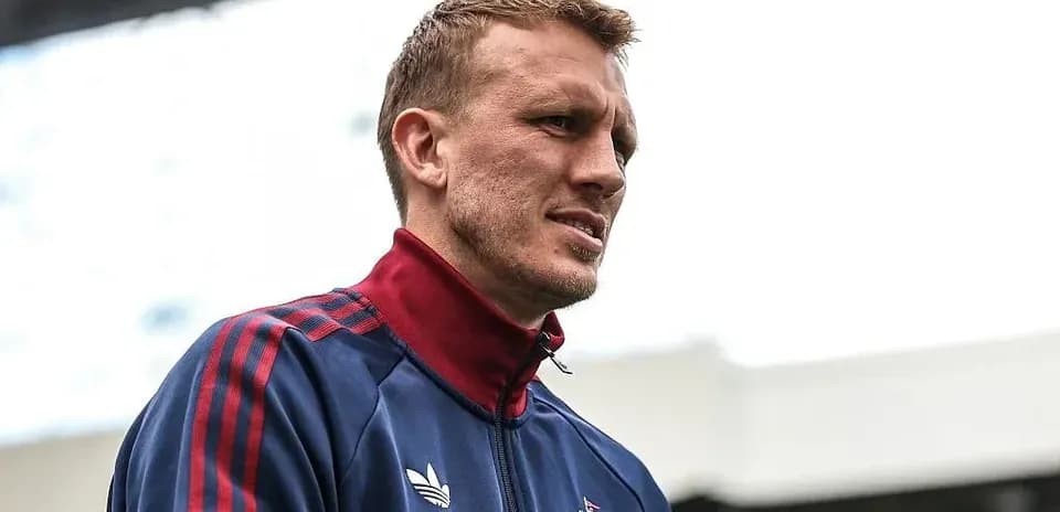 Player in team jacket standing at stadium entrance