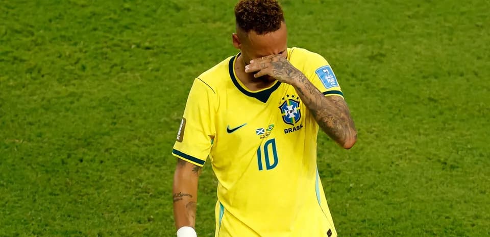 Player in yellow jersey wiping forehead on field