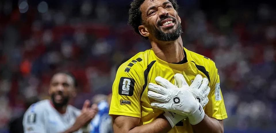Goalkeeper celebrating with gloves raised after match