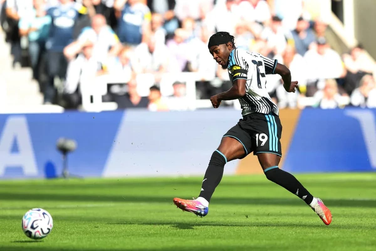Player in Newcastle United kit kicking a football