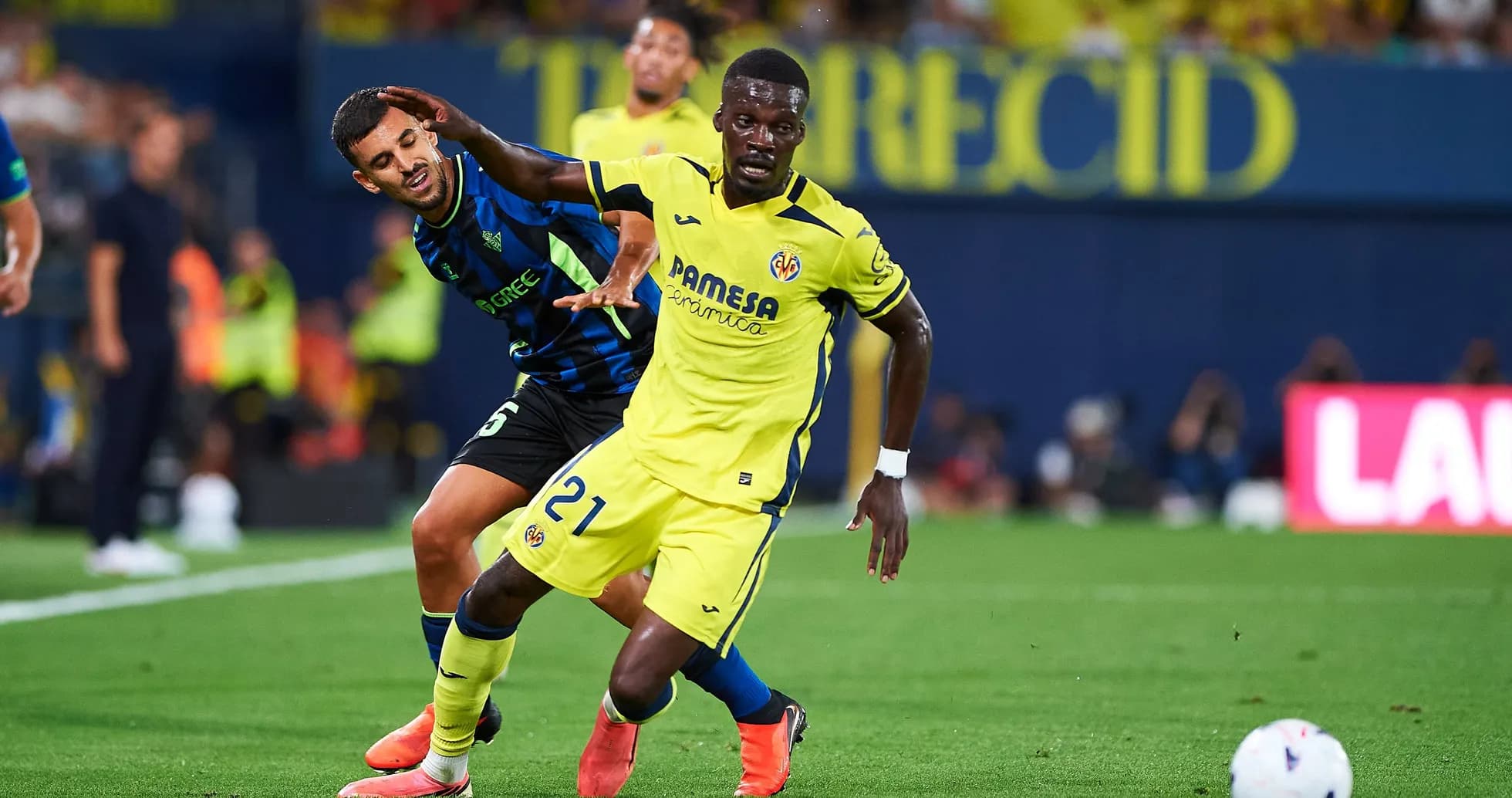 Player in yellow dribbling while being challenged by opponent