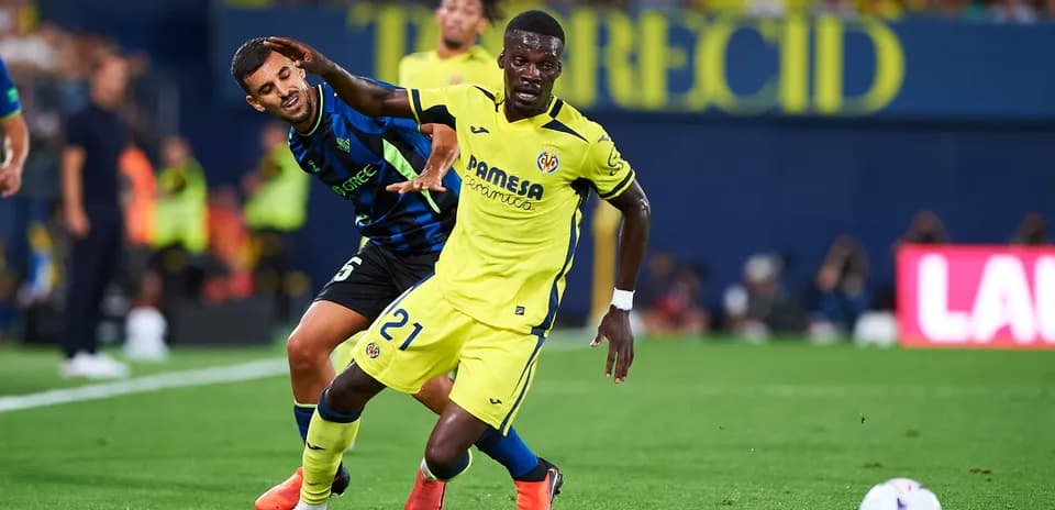 Player in yellow dribbling while being challenged by opponent