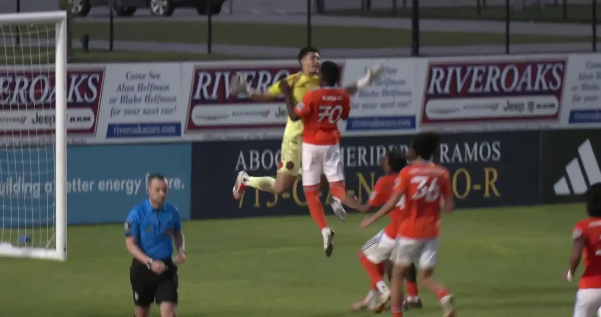 Goalkeeper jumping to catch the ball during match